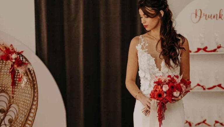 femme dans une robe de mariée avec un bouquet de fleurs rouges dans une boutique mariage à Laval