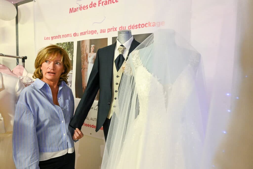 femme sur un stand avec des robes de mariée sur le salon du mariage avec Mariées de France Épinal